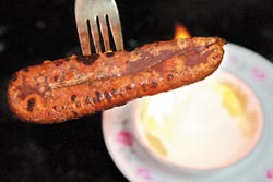 ▲火烤烏魚子，等雙面焦黃取出時約3分熟，外酥內軟，若偏好熟些則可烤久一點。攝影  陳志東